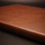 Close-up of a brown leather notebook on a dark surface