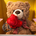Teddy bear with a red rose and plaid bow tie in a box with 'GOTSENT' branding.