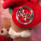 Close-up of a red plush toy with a silver emblem on a blurred background