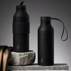 Two black water bottles on a stone surface with a gray background