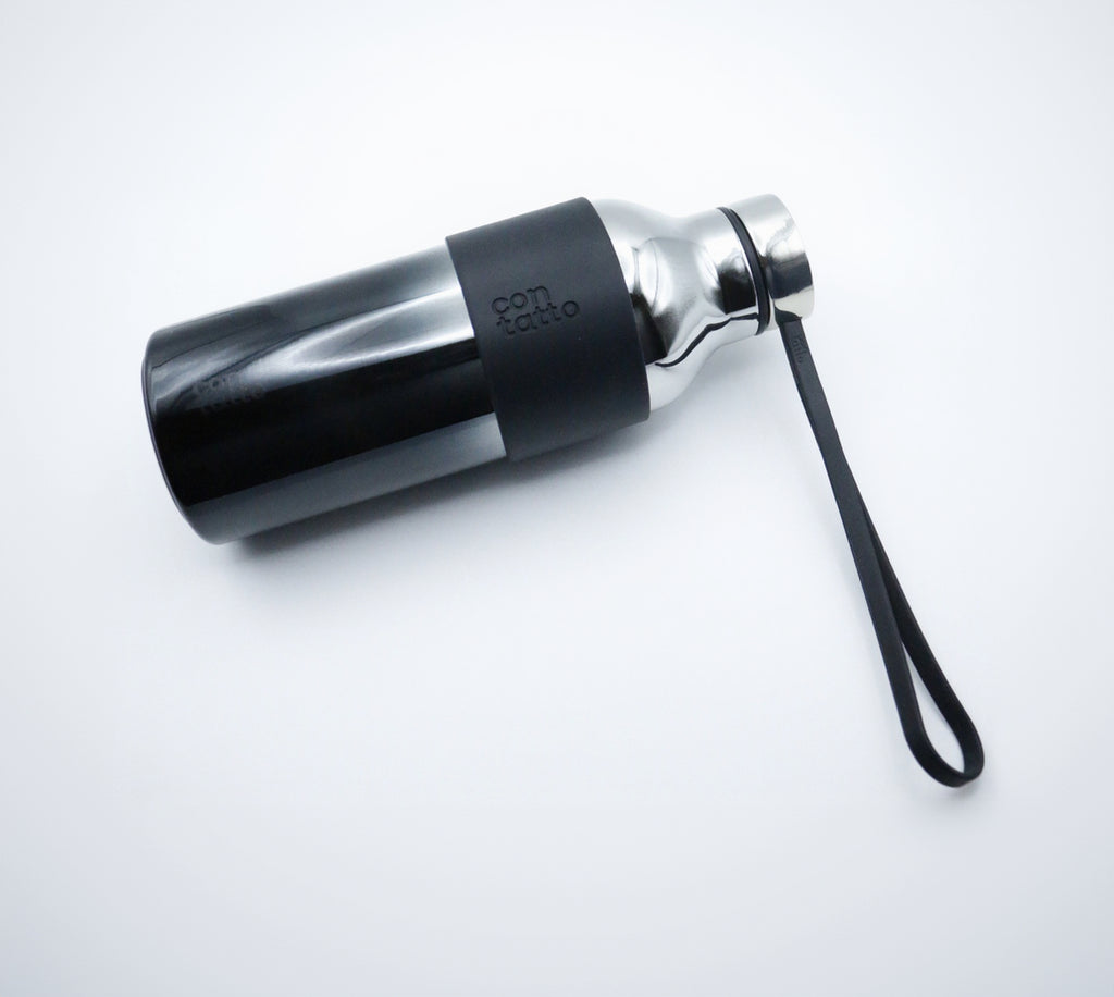 Silver and black water bottle with a strap on a white background