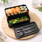 Black food container box set with sushi and salad. Image by GOTSENT.