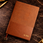 Brown leather notebook with textured cover and gold foil name personalisation.